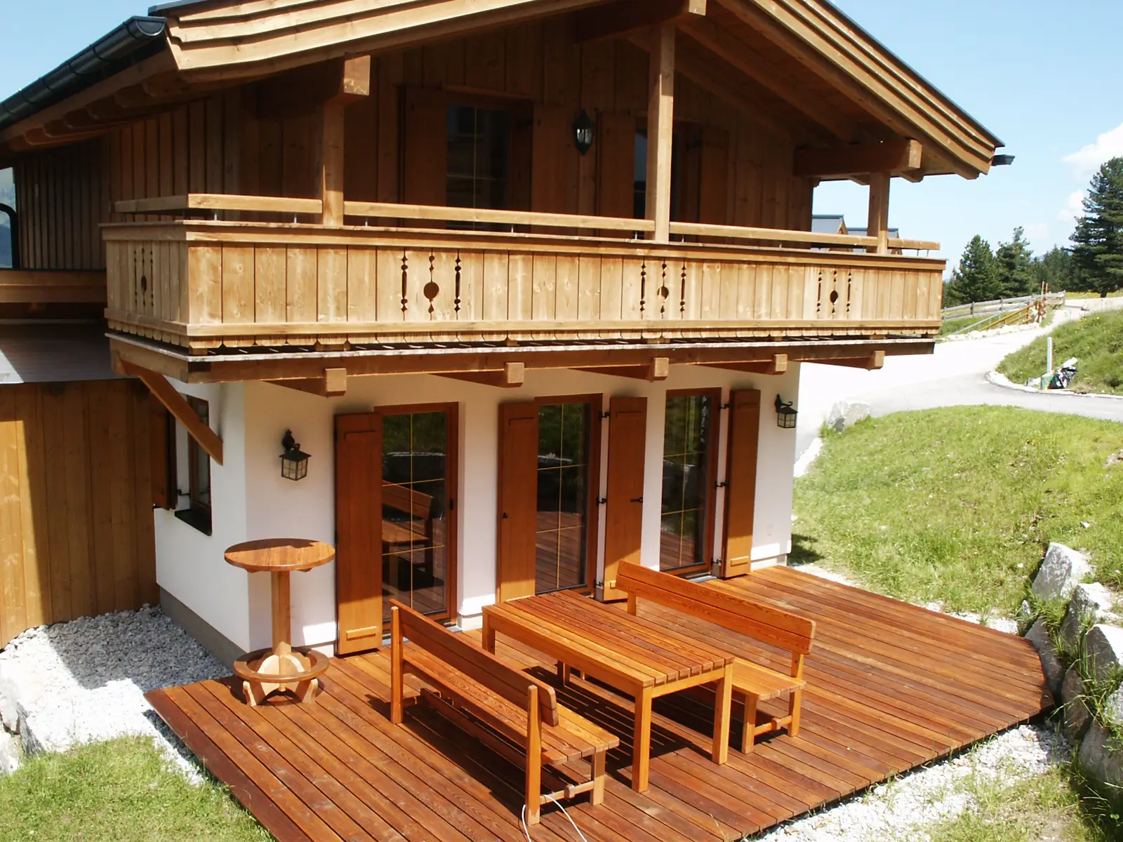 Almhaus Oscar im Sommer mit Holzterrasse, Balkon und grüner Almwiese